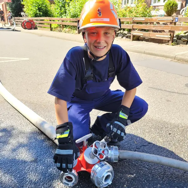 Junge mit Helm und Wasserleitung