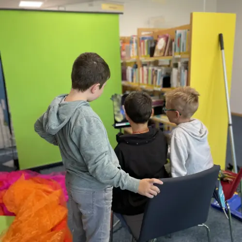 Kinder probieren sich an virtuellen Hintergründen für ihr Fotoshooting aus.